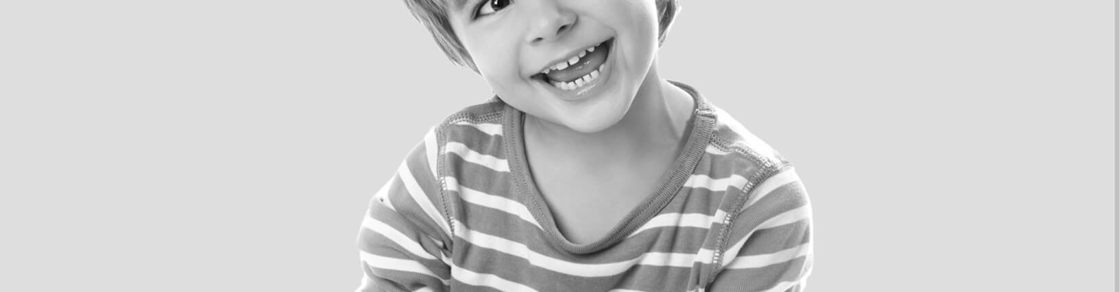 Photograph of Young Boy Smiling in Greyscale